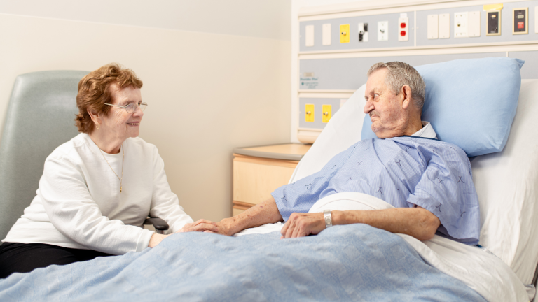 Senior Patient in Hospital Room with Spouse